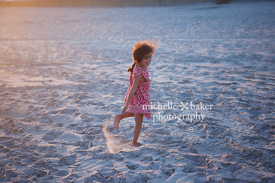 girl in pink dress on beach