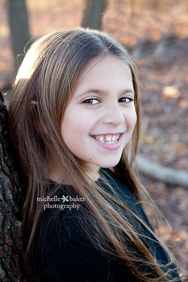 girl leaning up against a tree