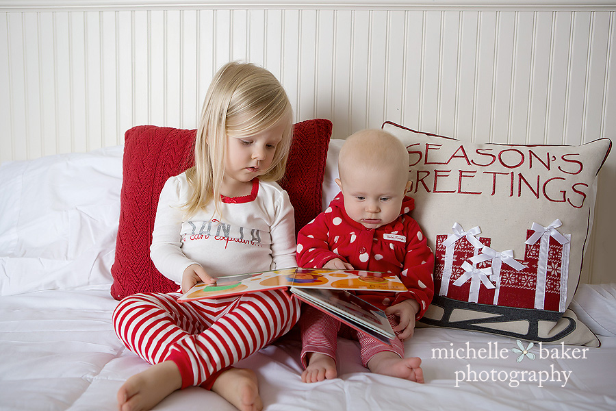 2 sisters reading on a bed in Holiday PJ's